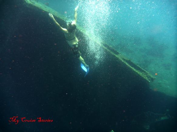 snorkeler diving near shipwreck